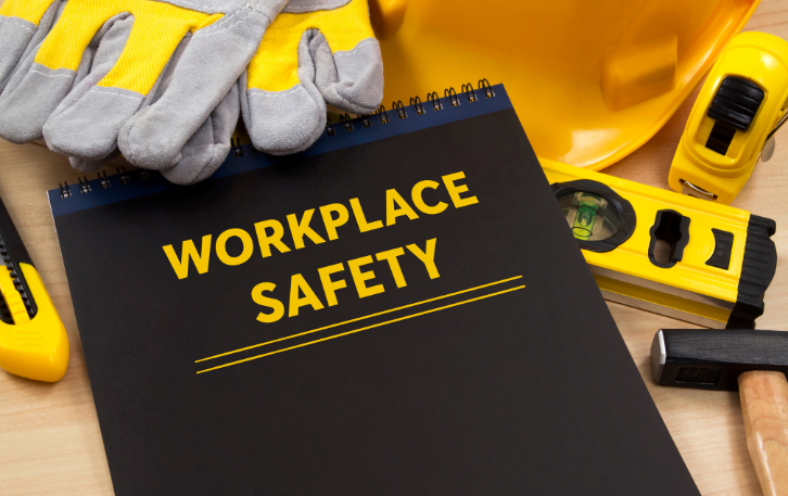 Notebook labeled "Workplace Safety" with construction tools surrounding it.