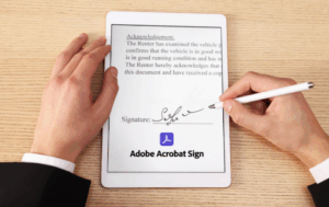 Hand with pen signing a tablet