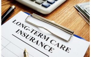desk with clipboard, calculator, and pen. text: "long term care insurance"