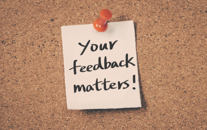 Post-It with words "Your Feedback Matters!" on corkboard